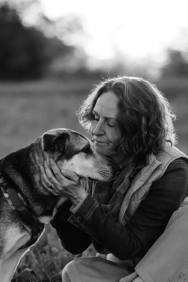 Schwarzweißfoto: Almut schmiegt ihr Gesicht an den Kopf ihrer Hündin Ylva